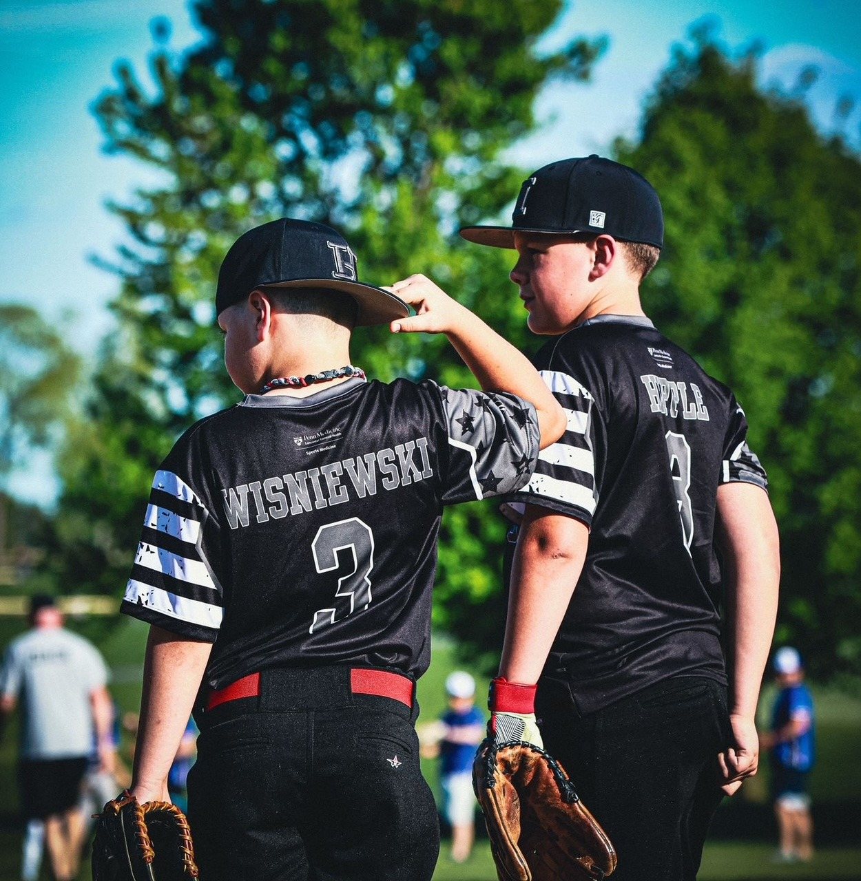 Nathanael standing with a teammate on the field